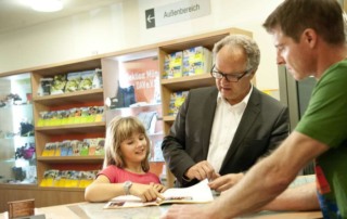Ein Mitarbeiter der Servicestelle Gilching der Sektion München berät einen Herrn und ein Kind